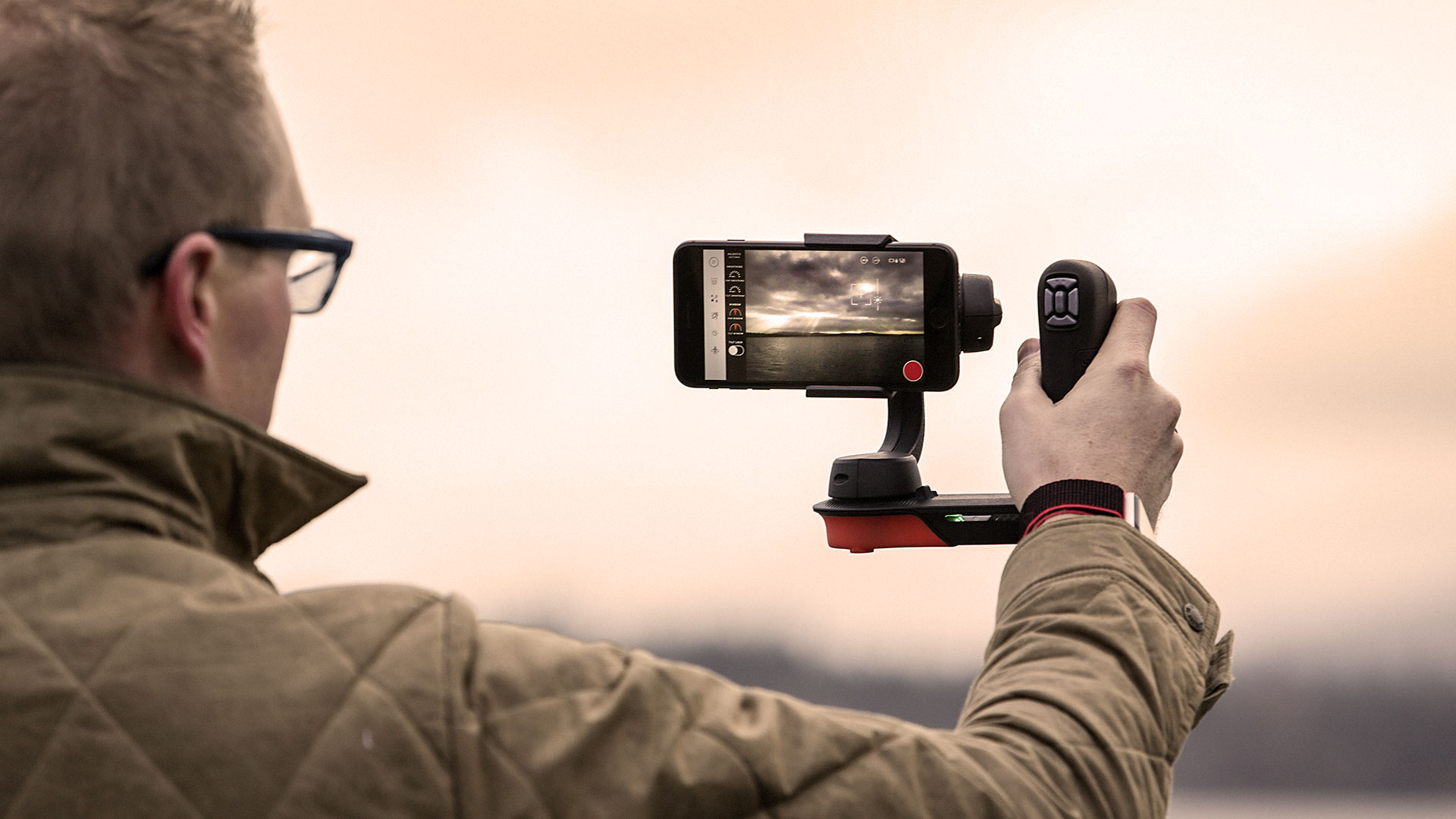 Photo of someone holding the Movi Cinema Robot against a dramatic sky